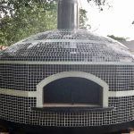 Forno Nardona Napoli wood fired oven with Willow Brook glass tile on a custom travertine base.