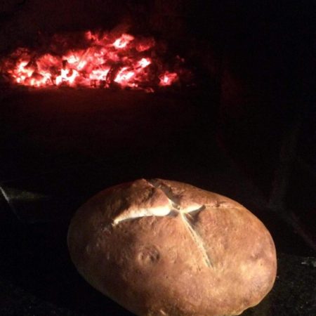 Bread being baked in a brick dome oven
