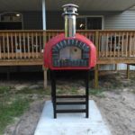 Outdoor pizza oven with red exterior in the Rustico Model