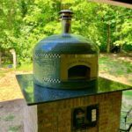 Forno Nardona Napoli glass-tiled wood-fired pizza oven on client built base of brick with granite countertop.