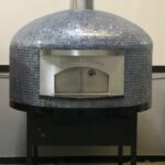 Forno Nardona Napoli oven with personalized face plate "Forno Celeiro" and Vidrepur Glass Mosaic Moon Collection tile.
