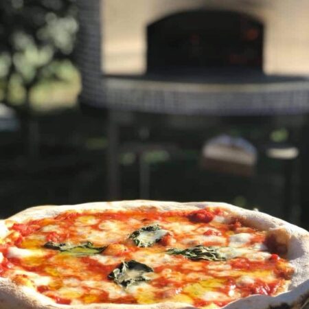 Neapolitan Pizza in the foreground of a Forno Nardona Napoli oven.