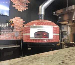 Forno Nardona Napolipizza oven in red and white glass tile with personalized face plate. It says: Brick City Eatery.