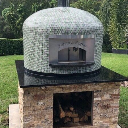 Backyard Pizza Oven Installation Done Right: A Forno Nardona Napoli wood fired pizza oven with Willow Brook glass tile on a custom travertine base.