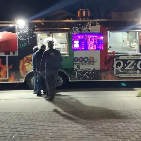 Sideview of a pizza food truck with at 48" Commercial Nardona Rustico oven to the left.