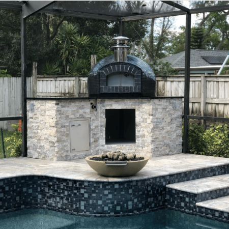 Forno Nardona Rustico 32" in black tile and black brick front on a Forno Nardona built base in stone and black granite poolside.