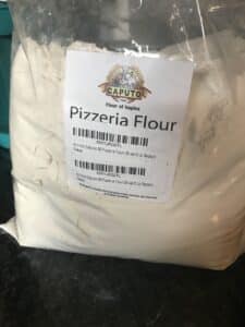 Clear bag of flour with Pizzeria Flour spelled out and a Caputo logo.