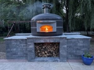 A Forno Nardona Napoli Oven on a large base with a nice file inside and smoke coming out the top. This is how you build a brick oven fire.