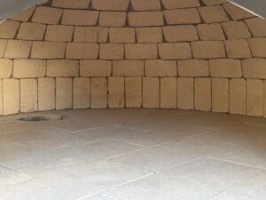 interior of a Forno Nardona dome showing the real fire brick done and floor with a hole in the back left for a burner made in Italy for a hybrid cooking experience
