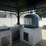 Personalized exterior door on blue 24" Napoli oven by Forno Nardona set in an outdoor kitchen with Lion Premium Accessories.