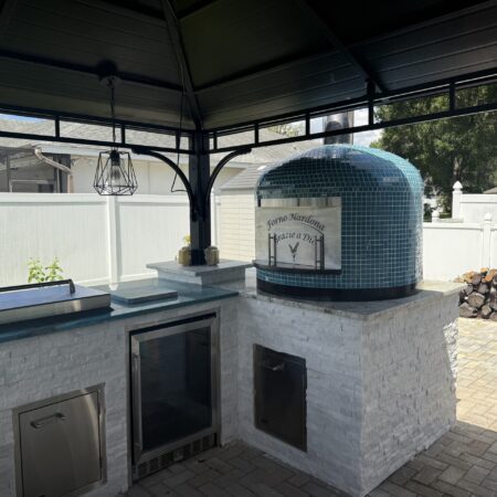 Personalized exterior door on blue 24" Napoli oven by Forno Nardona set in an outdoor kitchen with Lion Premium Accessories.
