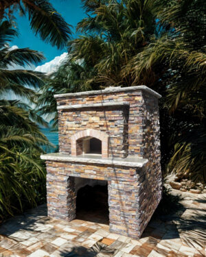 Firenze pizza oven by Forno Nardona on a custom base to store firewood set on a stone patio in a lush tropical setting.